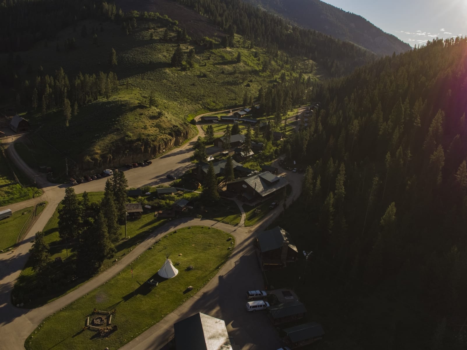 Drone photo over 320 ranch showing cabins, center lawn, and Montana's Gallatin National Forest.