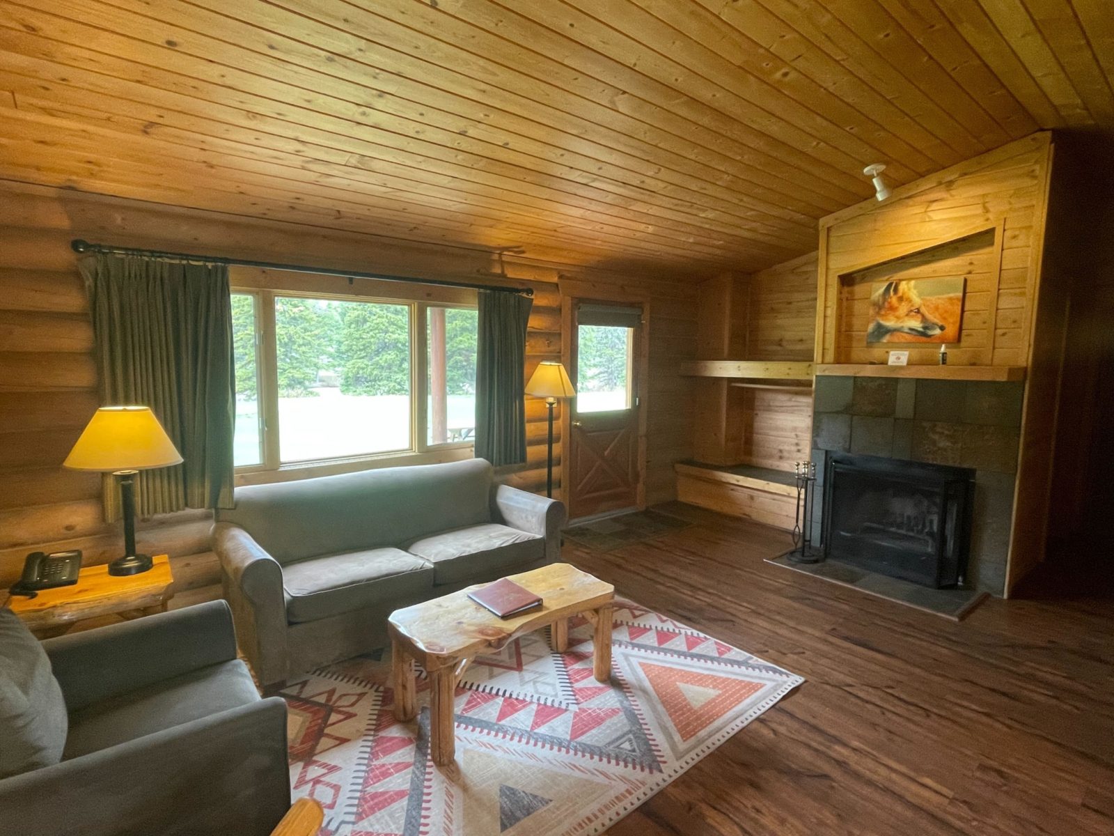 Living Room of 2 Bedroom river cabin with chair, pull out couch, and fireplace